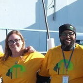 Speak for the Trees staff and board members standing and smiling with yellow T-shirts.