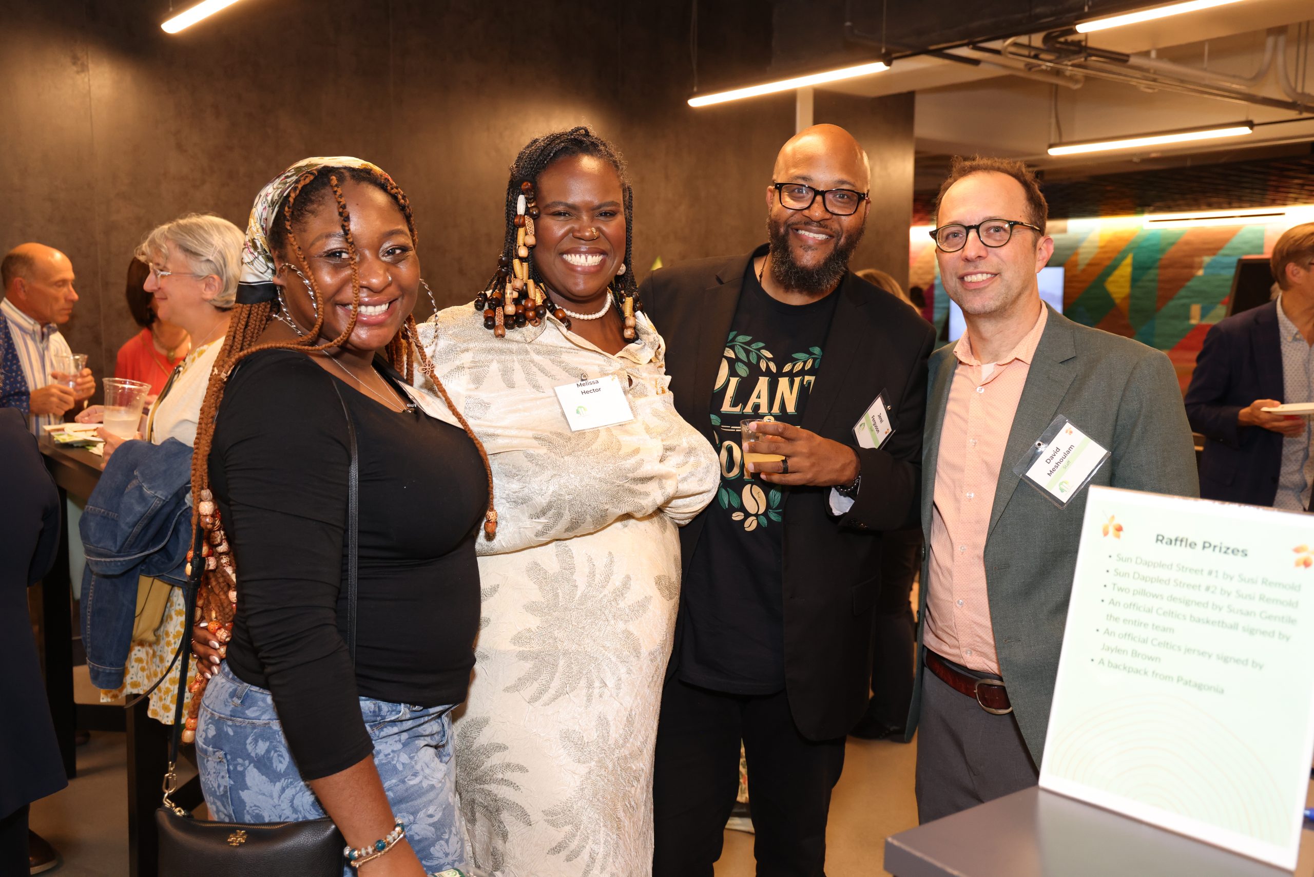 Four people smiling at our Summer Benefit